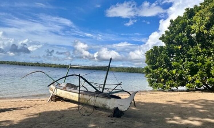 Moluccas, Halmahera: Little white wooden boat on the beach