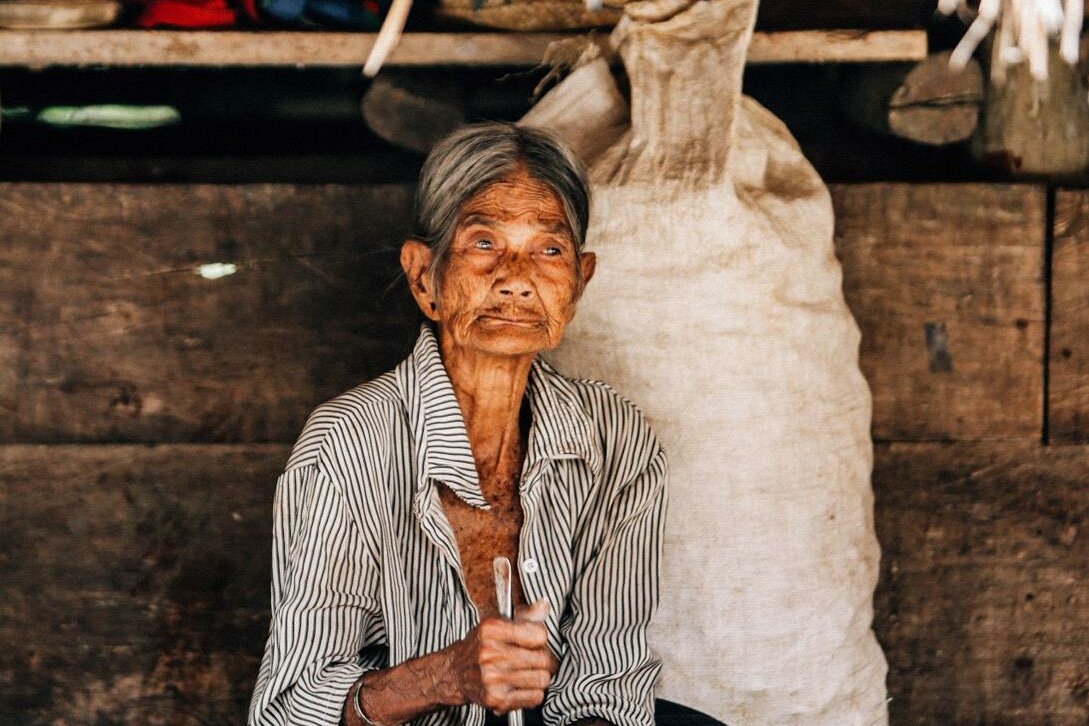 Indonesien, kleine Sundainsel Sumba: Alte Frau vor ihrem Haus