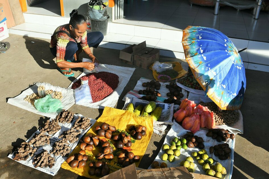 Molukken Gewürzinsel Halmahera: Eine Frau verkauft Obst und Erdnüsse auf einem lokalen Markt