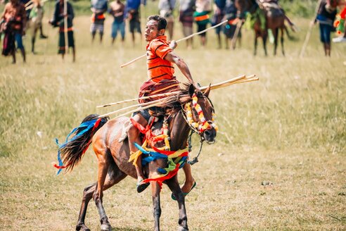 Pasola Festival auf Sumba, Indonesien: Reiter holt zum Speerwurf aus