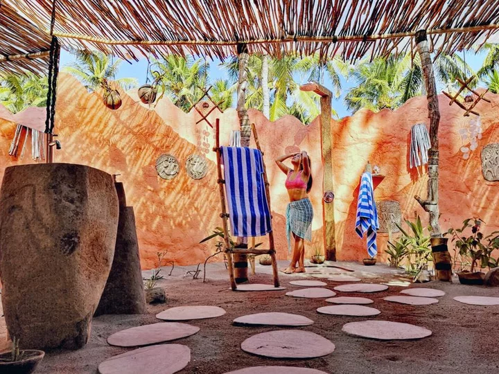 Indonesia, Flores: Coconut Garden Beach Resort, woman in bathroom with outdoor shower