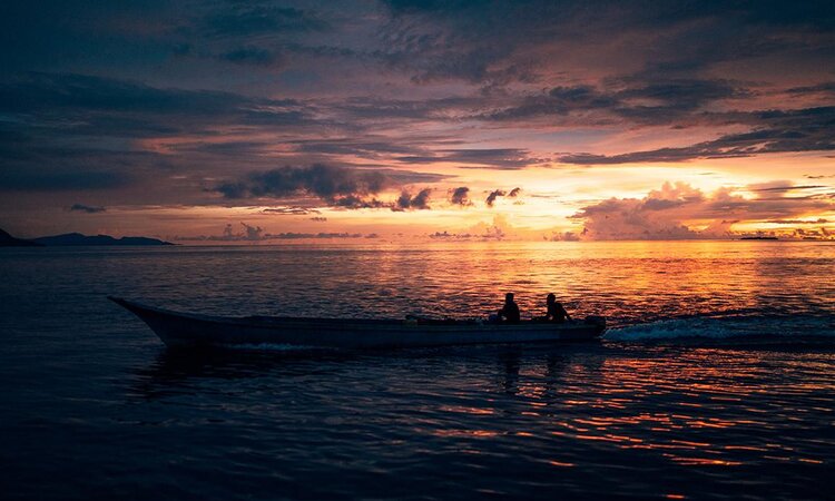 Raja Ampat Biodiversity Nature Resort: Fisherman in Wooden Boat at Sunrise