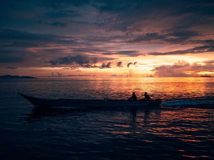 Raja Ampat Biodiversity Nature Resort: Fisherman in Wooden Boat at Sunrise
