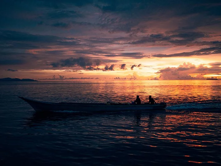  Raja Ampat Biodiversity Nature Resort: Fisherman in Wooden Boat at Sunrise