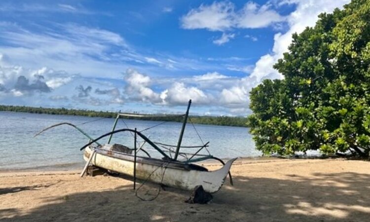 Molukken, Halmahera: Kleines weißes Holzboot am Kupa-Kupa Resort-Strand