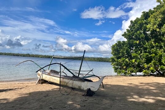 Molukken, Halmahera: Kleines weißes Holzboot am Kupa-Kupa Resort-Strand