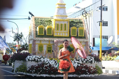 Tomohon Flower Festival: Mädchen vor Wagen mit Blumenhausdekoration I Girl in front of wagon with flower house decoration 