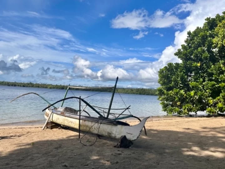 Moluccas, Halmahera: Little white wooden boat on the beach