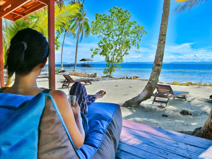 Cove Eco Resort, Raja Ampat: Ausblick auf Palmenstrand von Bungalowterrasse