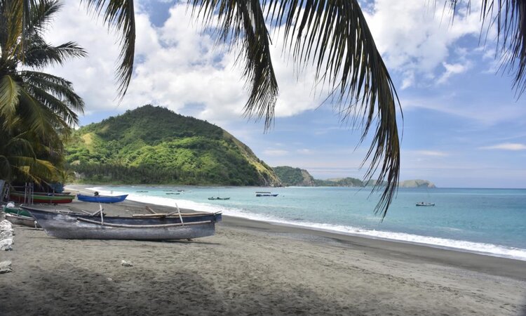 Tompotika Dive Lodge: Beach with wooden boats overlooking the mountains and sea