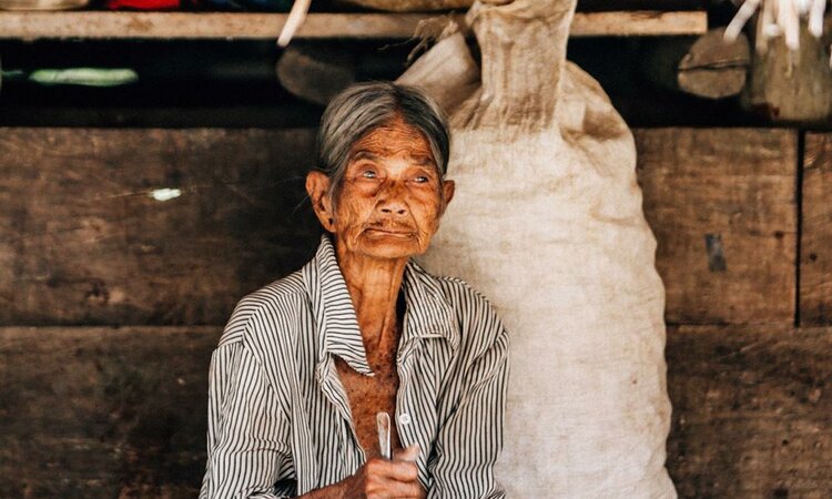 Indonesien, Insel Sumba: Alte Frau vor ihrem Haus