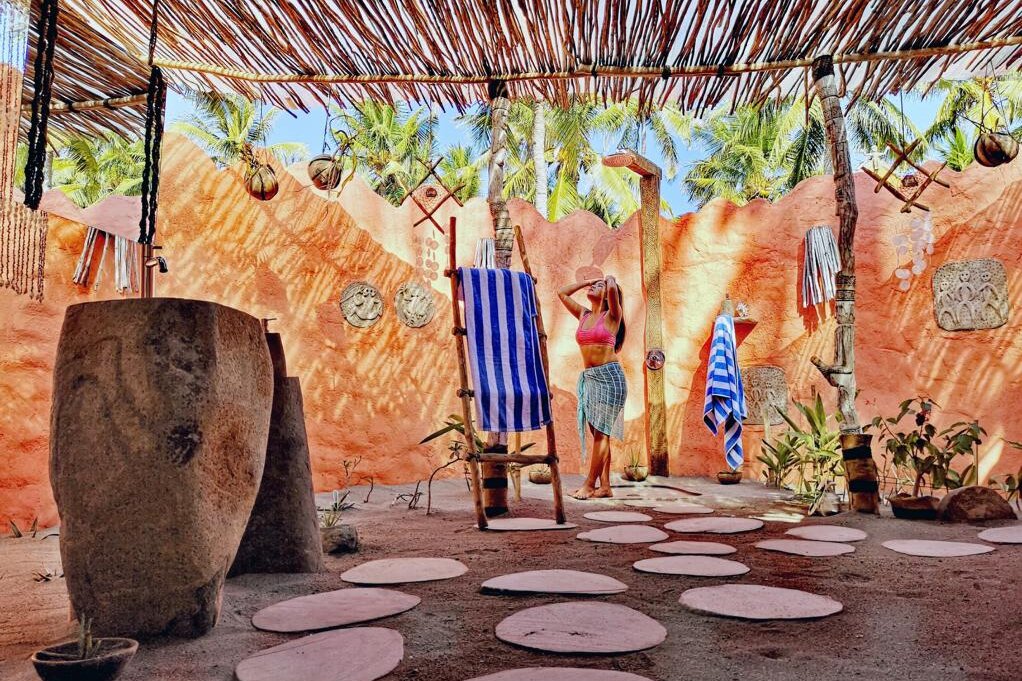 Indonesia, Flores: Coconut Garden Beach Resort, woman in bathroom with outdoor shower
