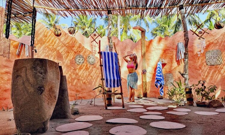 Indonesia, Flores: Coconut Garden Beach Resort, woman in bathroom with outdoor shower
