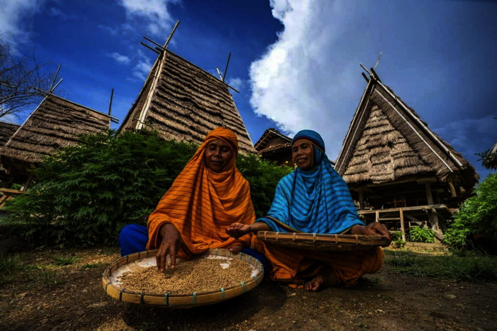 Zwei Frauen vor den Häusern ihres traditionellen Dorfes in Ost-Sumbawa, Indonesien