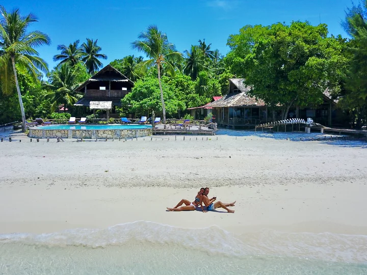 Raja Ampat Agusta Eco Resort with beach enthusiasts on white sandy beach