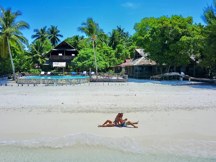  Raja Ampat Agusta Eco Resort with beach enthusiasts on white sandy beach
