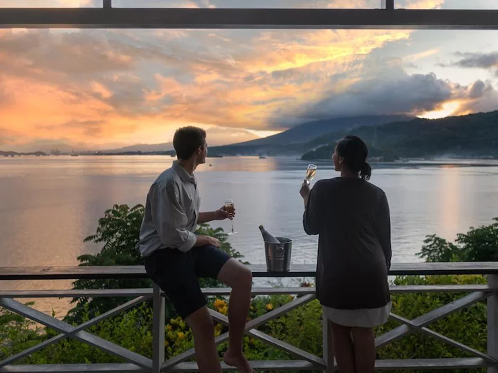  Couple enjoying the sunset from the terrace at Lembeh Resort, Lembeh Island - Sulawesi