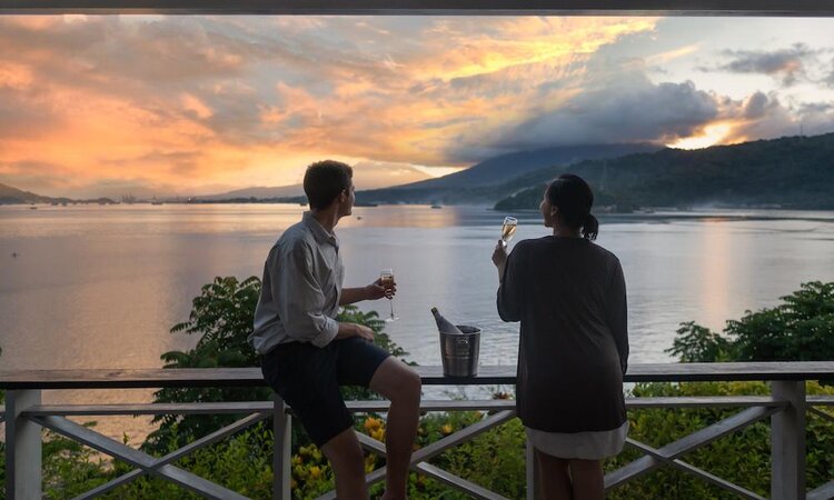 Paar genießt Sonnenuntergang von Terrasse im Lembeh Resort, Insel Lembeh - Sulawesi