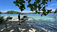 indonesien-mann-mit-kleinem-holzboot-an-weißem-sandstrand