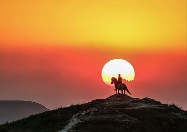 Indonesia, Sumba Island: Rider on hill at sunset