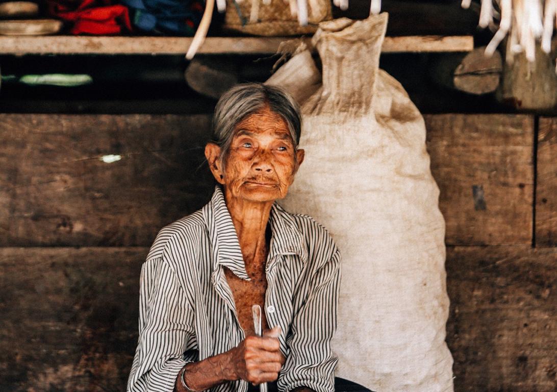 Indonesien, Insel Sumba: Alte Frau vor ihrem Haus